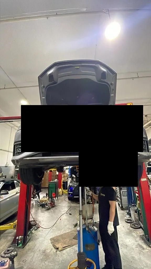 Audi A6 raised on the hoist for gearbox oil sump access at our Singapore workshop