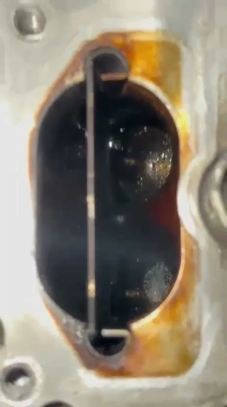 Audi A7 intake port showing heavy carbon buildup on the intake valves before walnut blasting