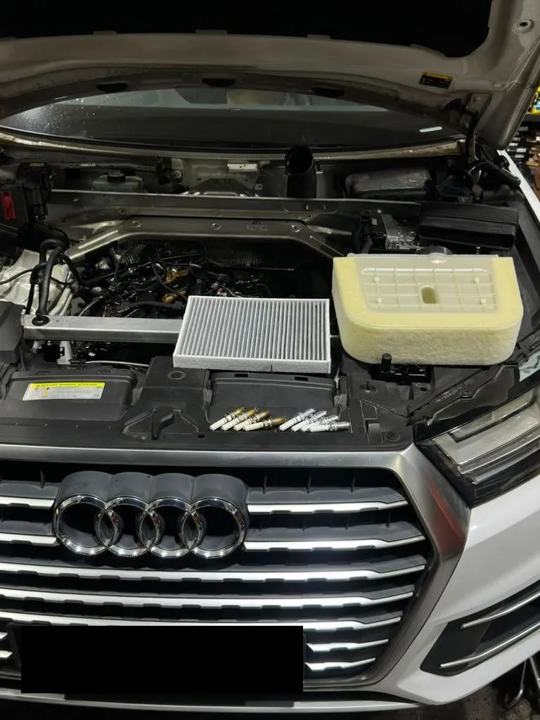 New spark plugs and filters laid out on an Audi engine before fitting at our Singapore workshop