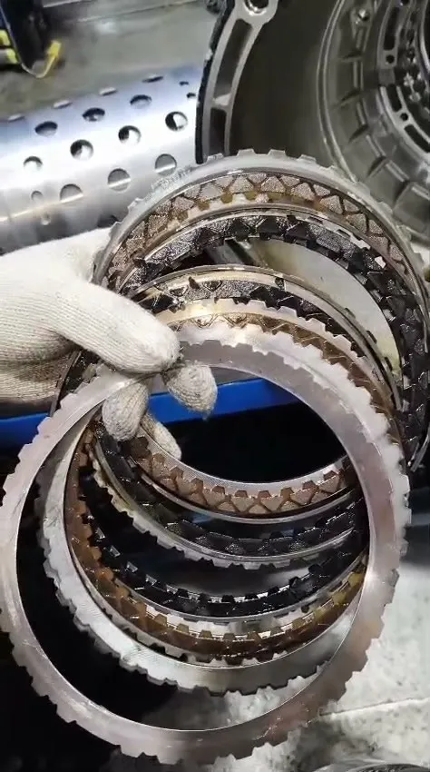 Burnt and glazed clutch friction discs removed from the BMW 218 gearbox during overhaul, showing heavy heat damage