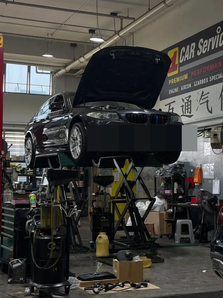 BMW 5 Series F10 raised on the workshop lift with bonnet open at 1 Car Service Singapore
