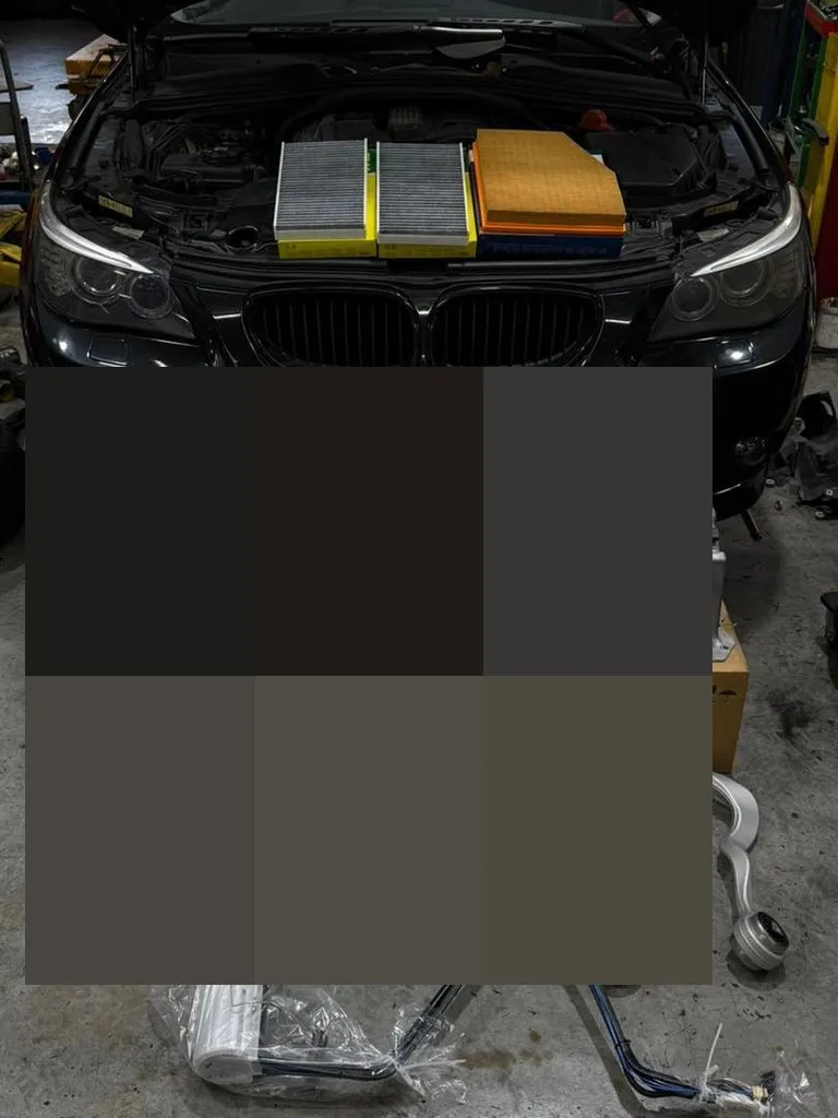 BMW 5 Series at our Singapore workshop with bonnet open and replaced parts laid out after a comprehensive oil leak and suspension repair