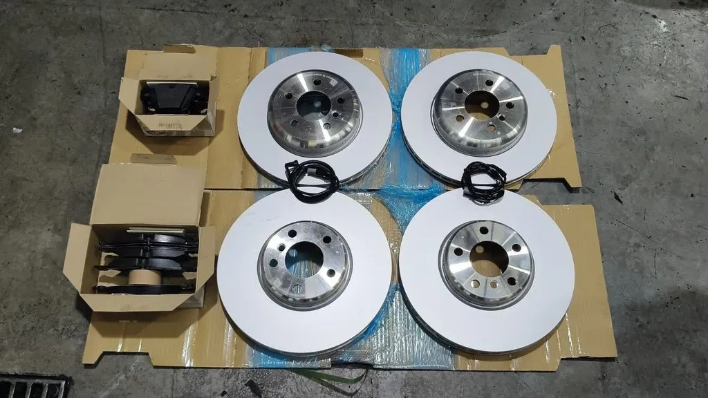 New brake discs and pads laid out for a BMW 740Li front and rear brake job at our Singapore workshop
