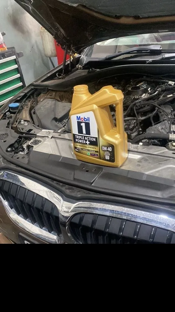 BMW with bonnet open and Mobil 1 0W-40 oil ready, at 1 Car Service workshop Singapore