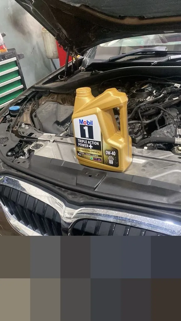 BMW with bonnet open and Mobil 1 0W-40 oil ready, at 1 Car Service workshop Singapore