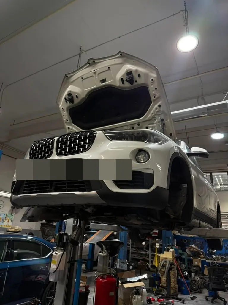 BMW X1 raised on the workshop lift at our Singapore workshop for a gearbox overhaul and torque converter replacement
