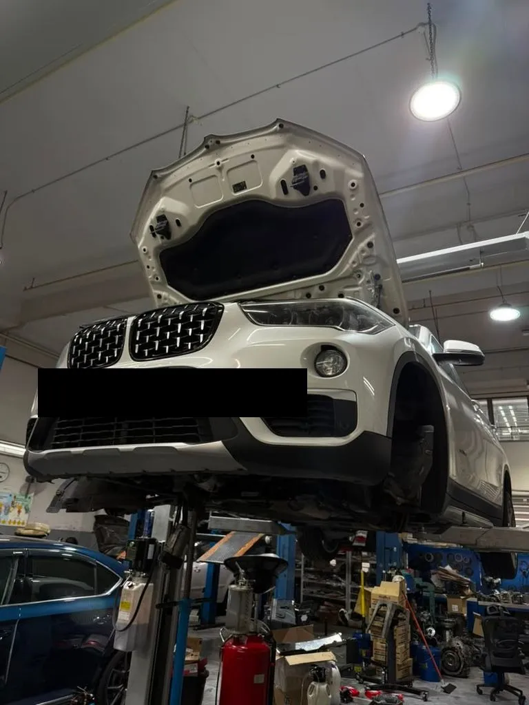 BMW X1 raised on the workshop lift at our Singapore workshop for a gearbox overhaul and torque converter replacement