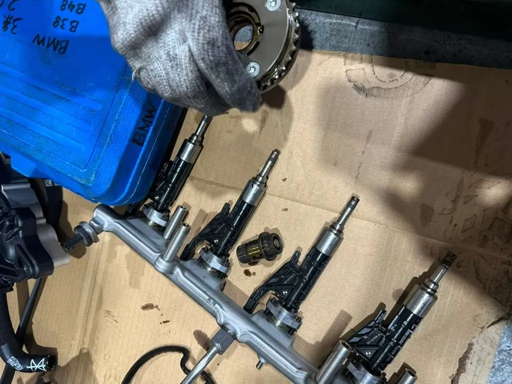 BMW X4 timing components including cam gear sprocket and injector rail removed during timing kit replacement at our Singapore workshop