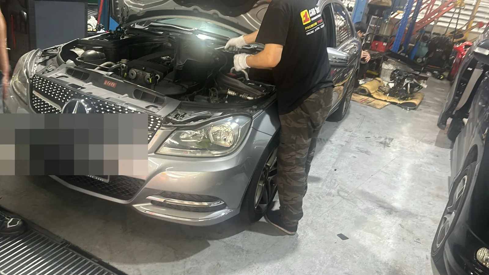 Our technician working in the engine bay of a customer's Mercedes-Benz at our Singapore workshop