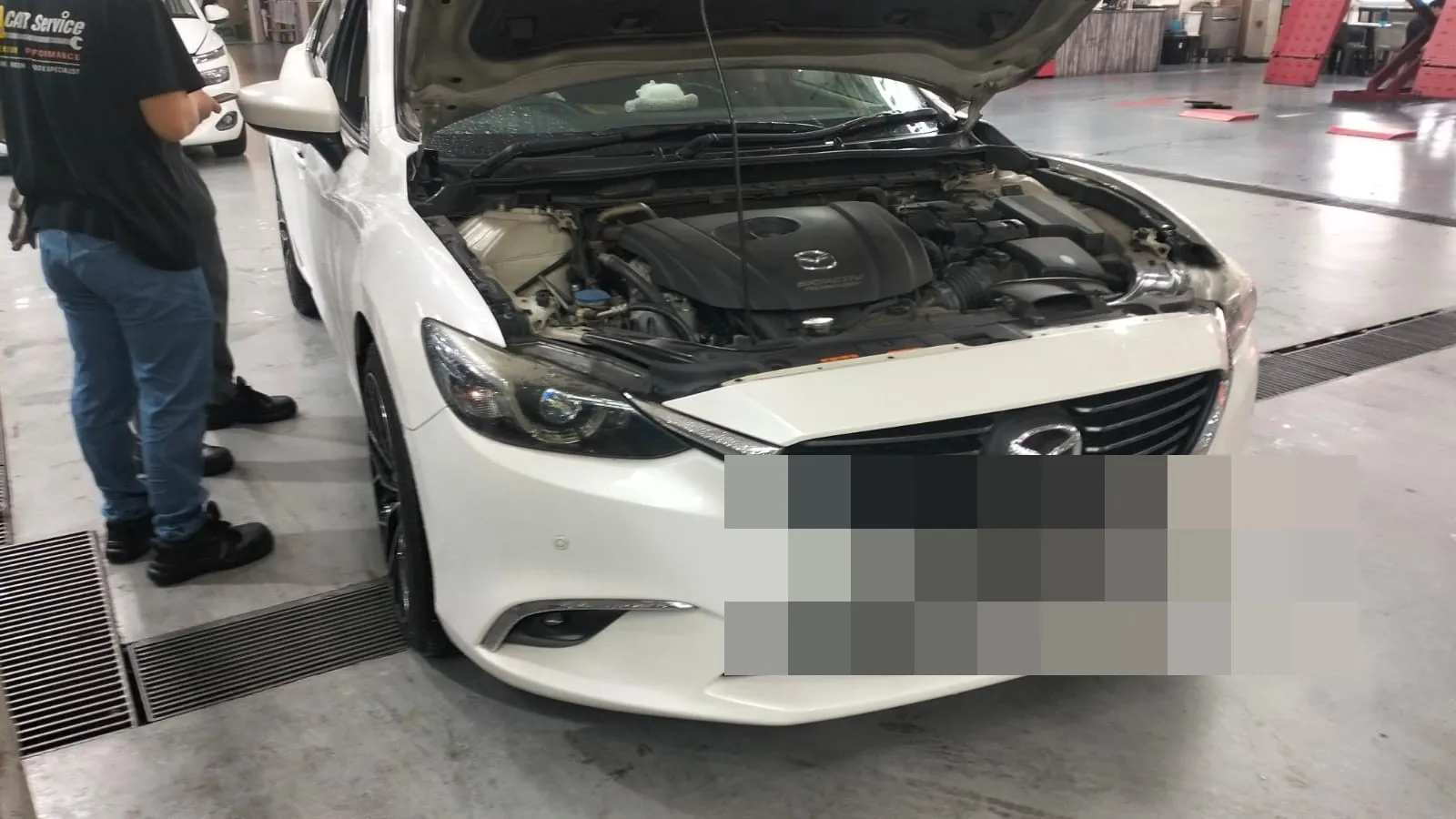 Our technician inspecting the engine bay of a customer's Mazda at our Singapore workshop