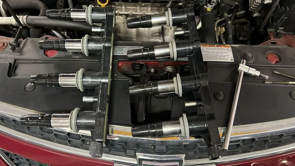Four ignition coils laid out during replacement on a Chevrolet Cruze in Singapore