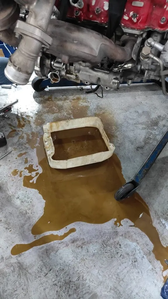 Milk-tea coloured engine oil drained from a Ferrari 488, showing coolant mixed into the oil