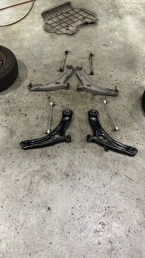 Old rusty Honda Freed lower arm next to new replacement lower arm at 1 Car Service Singapore workshop