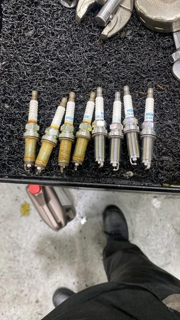Worn spark plugs removed from a Honda Freed during service