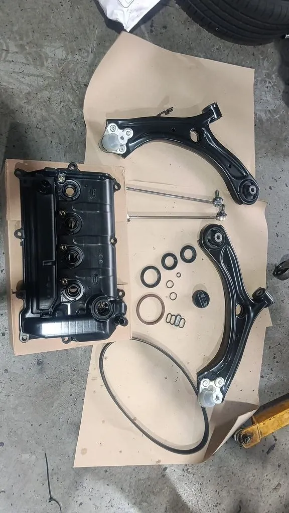Honda HR-V new valve cover assembly, lower control arms, oil seals and fan belt laid out before fitting at 1 Car Service Singapore