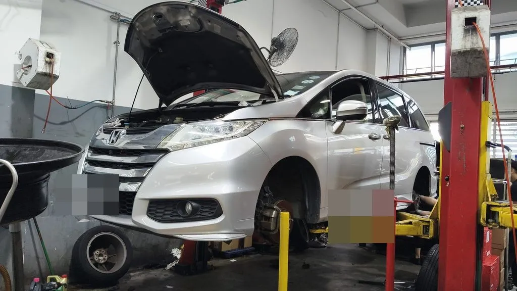Silver Honda Odyssey up on the lift at our Singapore workshop for a brake pad and disc rotor replacement