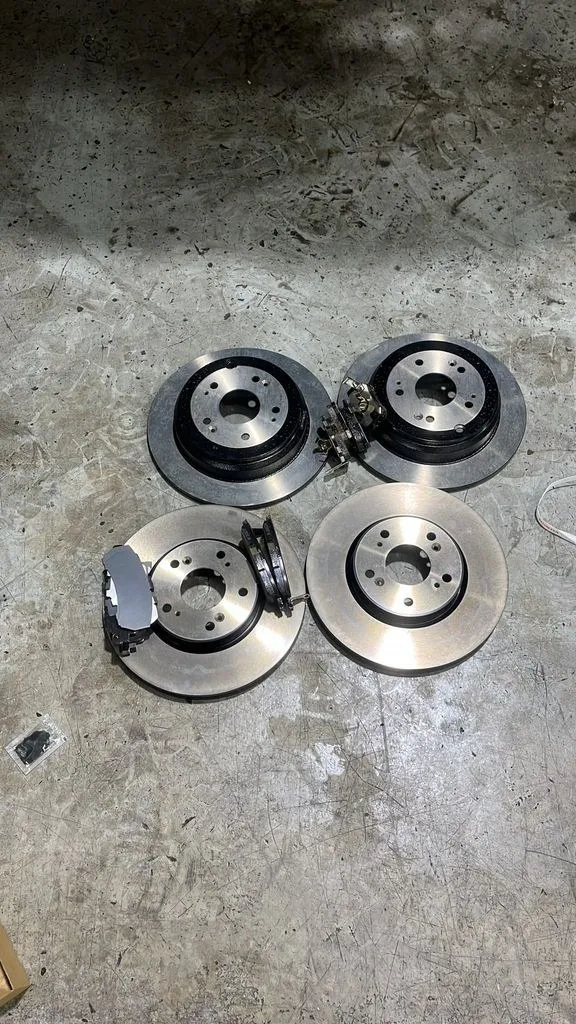Worn brake rotors and pads removed from a car during brake replacement in Singapore