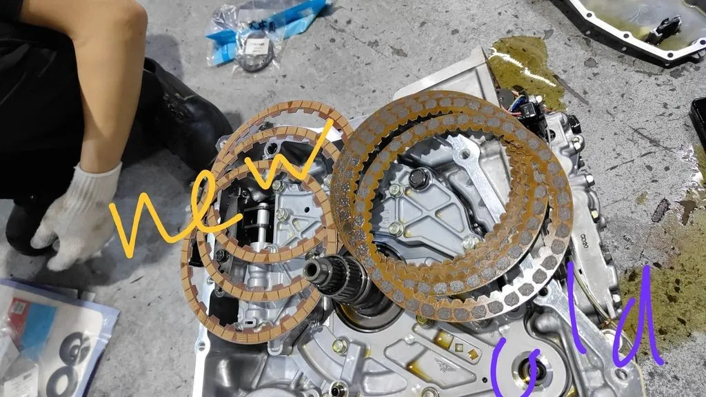 Worn clutch friction plates next to fresh plates from a Honda Odyssey automatic gearbox at our Singapore workshop