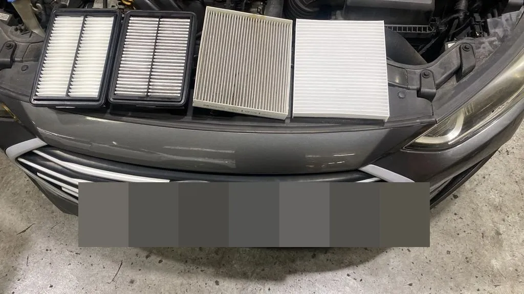 Old versus new engine air filter and cabin filter from a Hyundai Elantra, laid out on the bonnet at our Singapore workshop