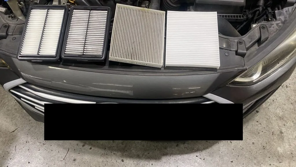 Old versus new engine air filter and cabin filter from a Hyundai Elantra, laid out on the bonnet at our Singapore workshop
