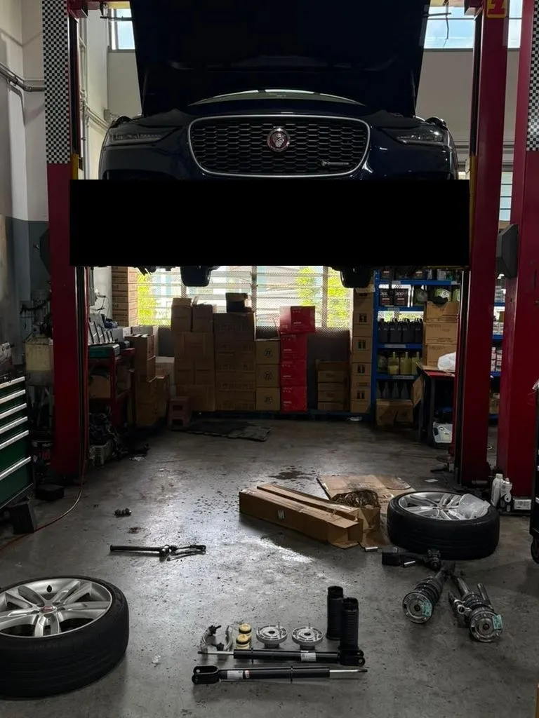 Jaguar F-Pace raised on workshop lift during front suspension replacement at 1 Car Service Singapore