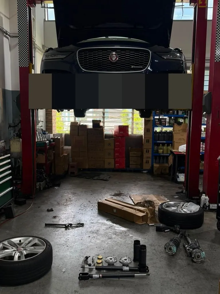 Jaguar XE raised on workshop lift during front suspension replacement at 1 Car Service Singapore