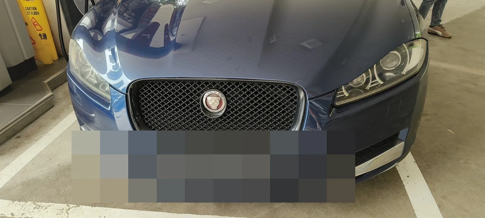 Jaguar sedan parked indoors, front view
