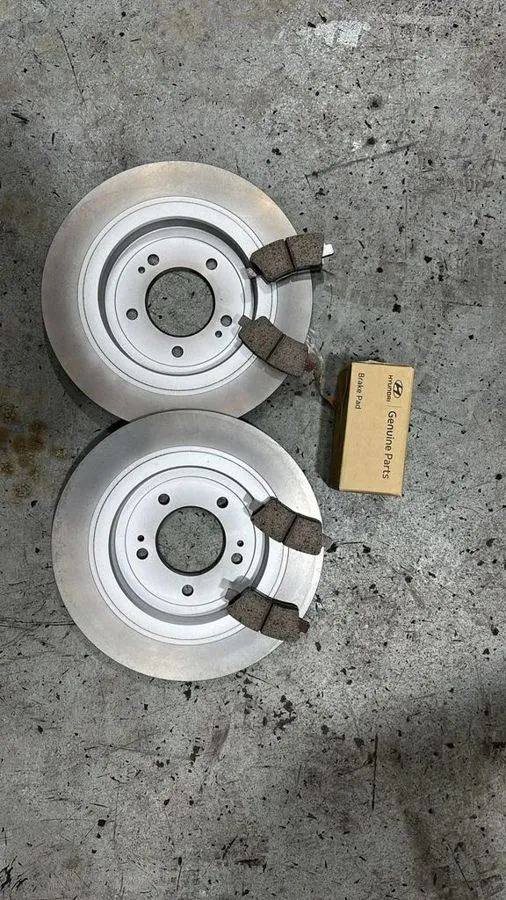 New Hyundai Genuine Parts brake discs and pads laid out for the Kia Sportage service at our Singapore workshop