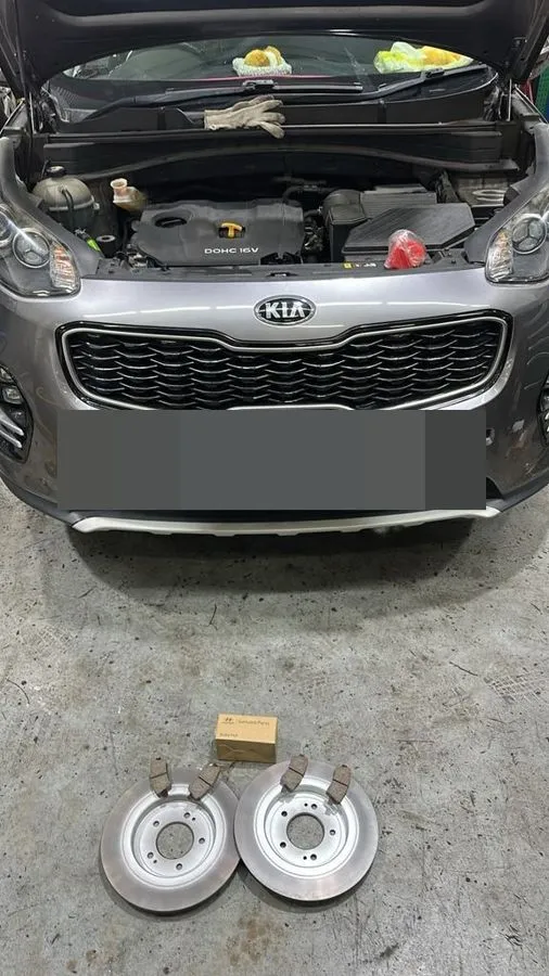 Kia Sportage at our workshop with new Hyundai Genuine Parts brake discs laid out in front ready for fitting