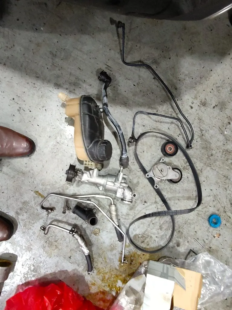 Removed parts from Mercedes-Benz A180 waterpump and belt job laid out at 1 Car Service Workshop