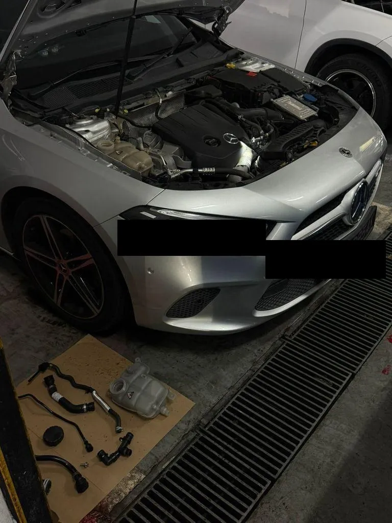 Mercedes-Benz in the workshop with the engine bay opened for coolant leak inspection