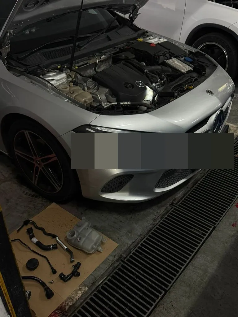 Mercedes-Benz in the workshop with the engine bay opened for coolant leak inspection