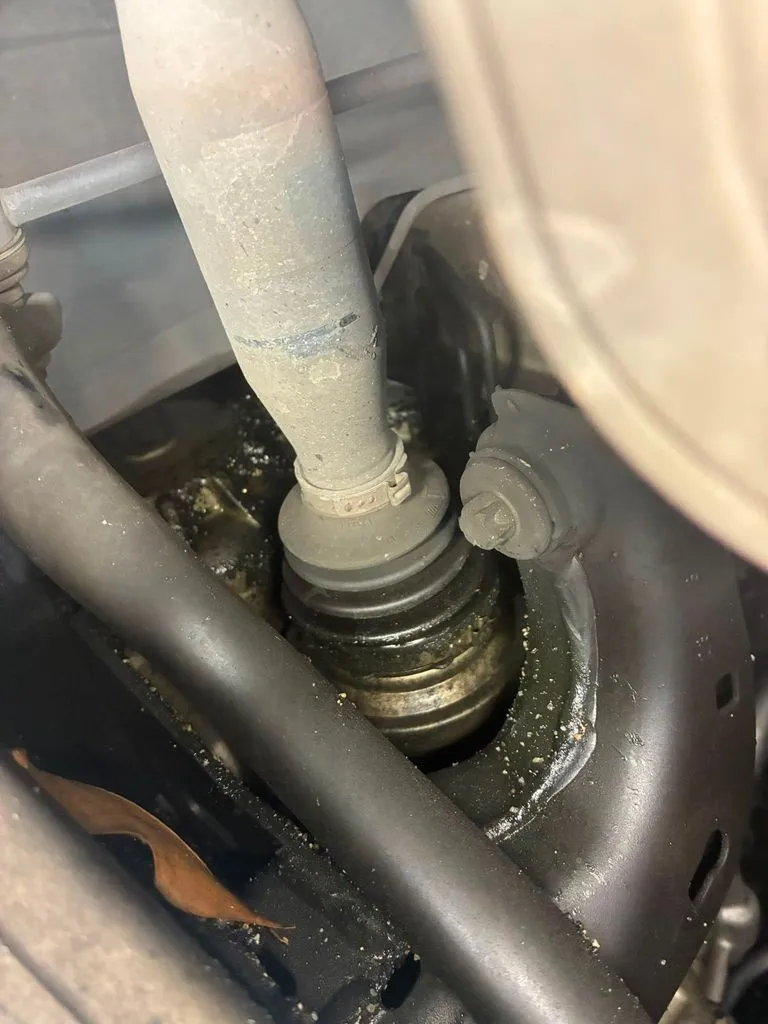 Torn CV boot on Mercedes-Benz CLA180 front driveshaft showing grease leakage, photographed before removal at our Singapore workshop