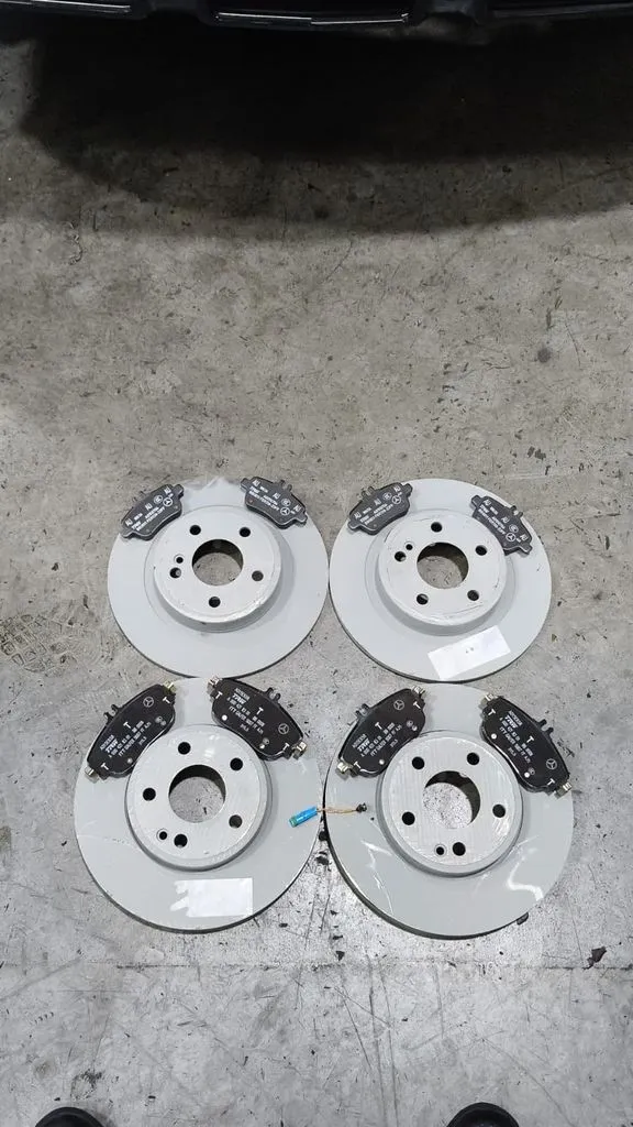 New OEM brake discs and pads laid out before fitting at our Singapore workshop