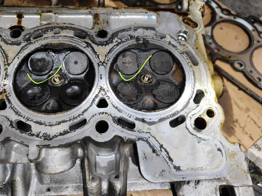 Defective engine valve marked on a Nissan Qashqai cylinder head during diagnosis in Singapore