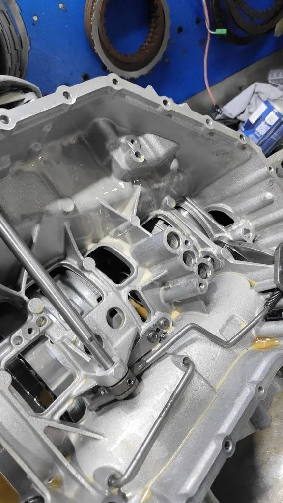 Inside view of a Porsche Cayman Tiptronic gearbox casing showing milky coolant contamination in the transmission oil passages