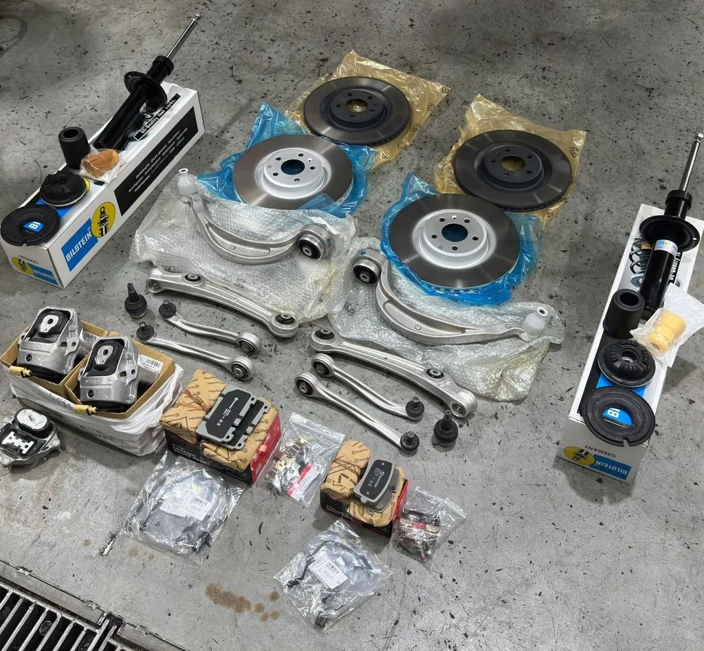 Porsche Macan engine mount, Brembo brake discs, control arms and brake pads laid out before installation at 1 Car Service Singapore