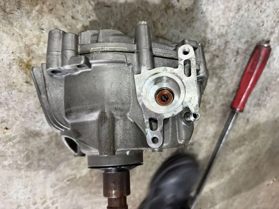 Old Porsche Macan PTU removed from the car, showing the failed output shaft seal where transfer-case fluid was leaking