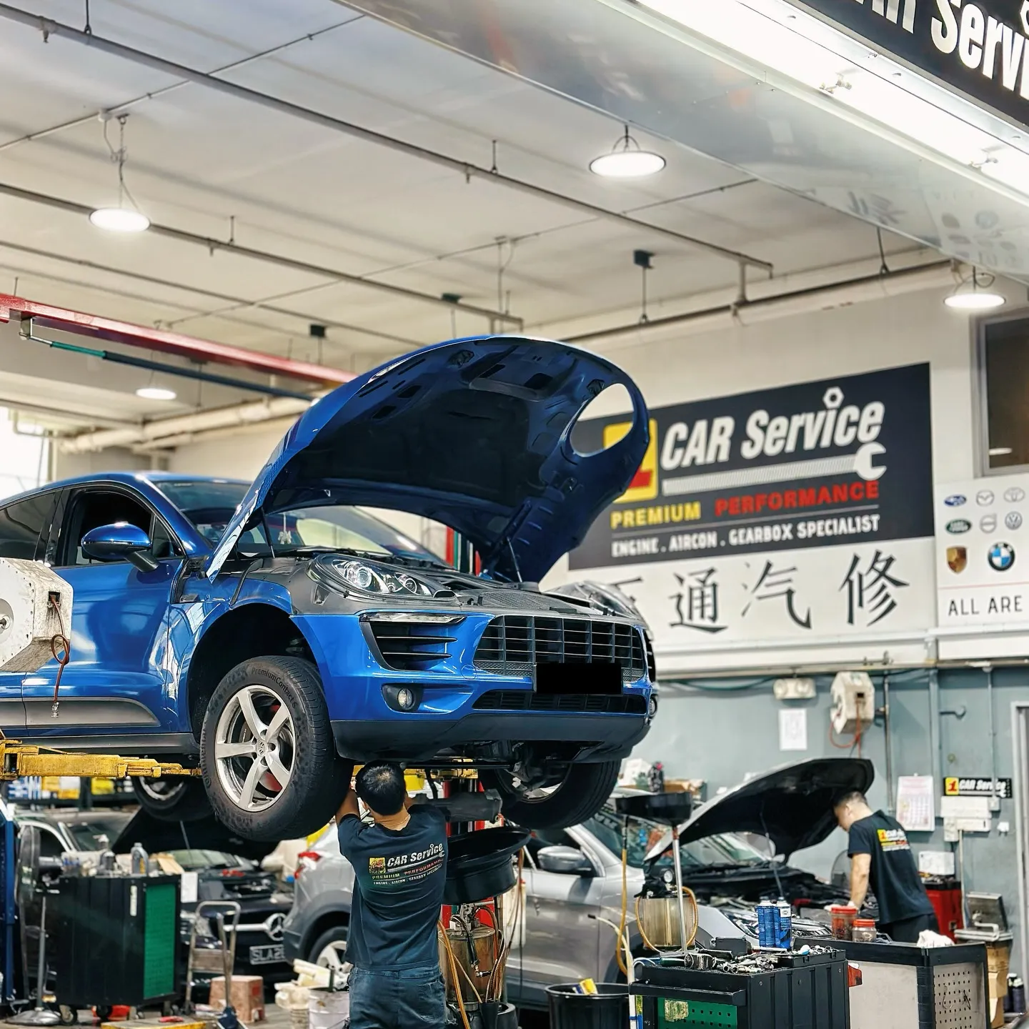 A Porsche Macan on the workshop lift for air suspension work in Singapore