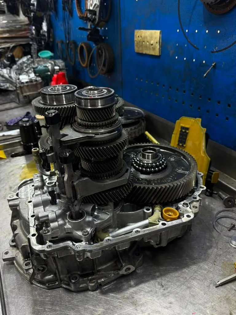 Skoda Superb DSG gearbox internal components stripped and laid out on the workshop bench during an overhaul in Singapore