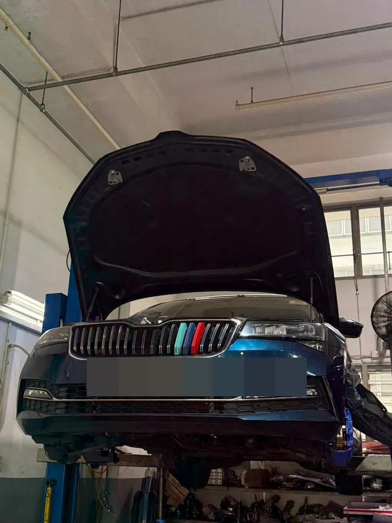 Skoda Superb on a lift with the bonnet open in the workshop