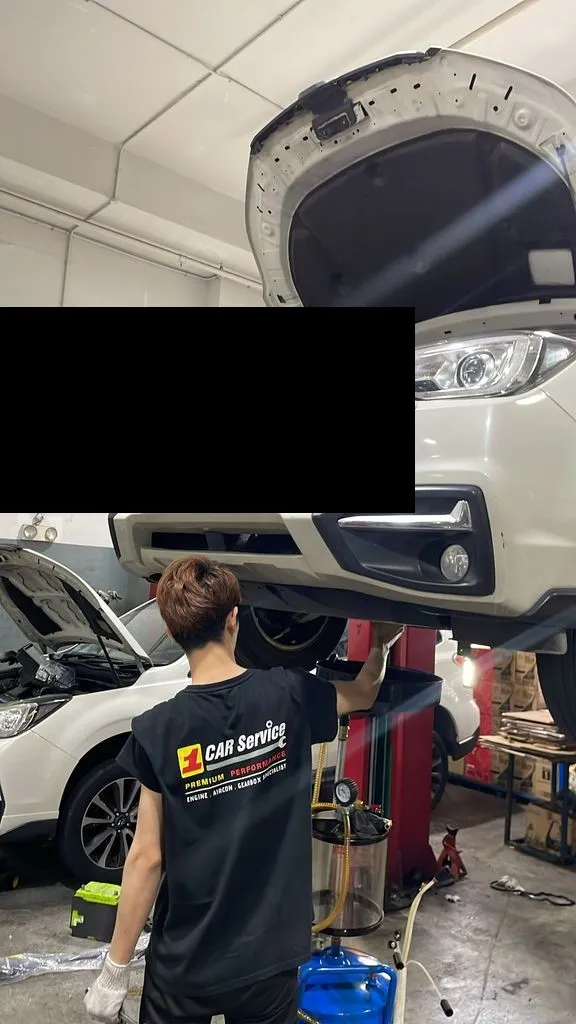 Subaru Forester raised on a lift for aircon compressor replacement at our Singapore workshop
