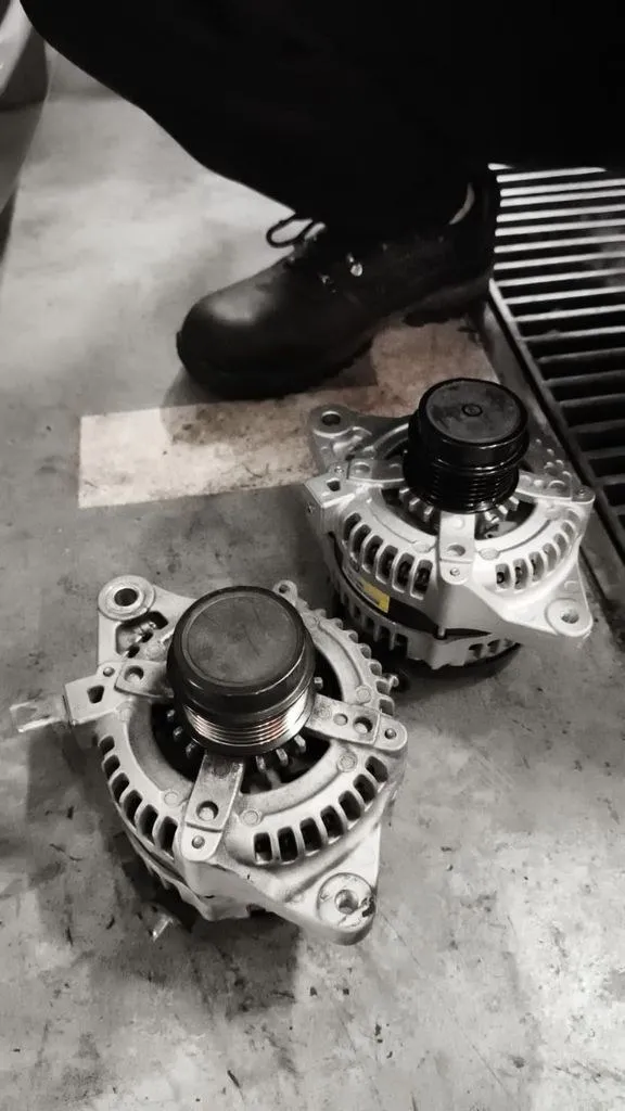 Replacement alternator next to the failed unit for a Toyota