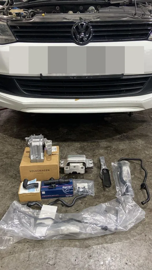 New engine mounts and air pipes laid out in front of a Volkswagen Jetta at our Singapore workshop