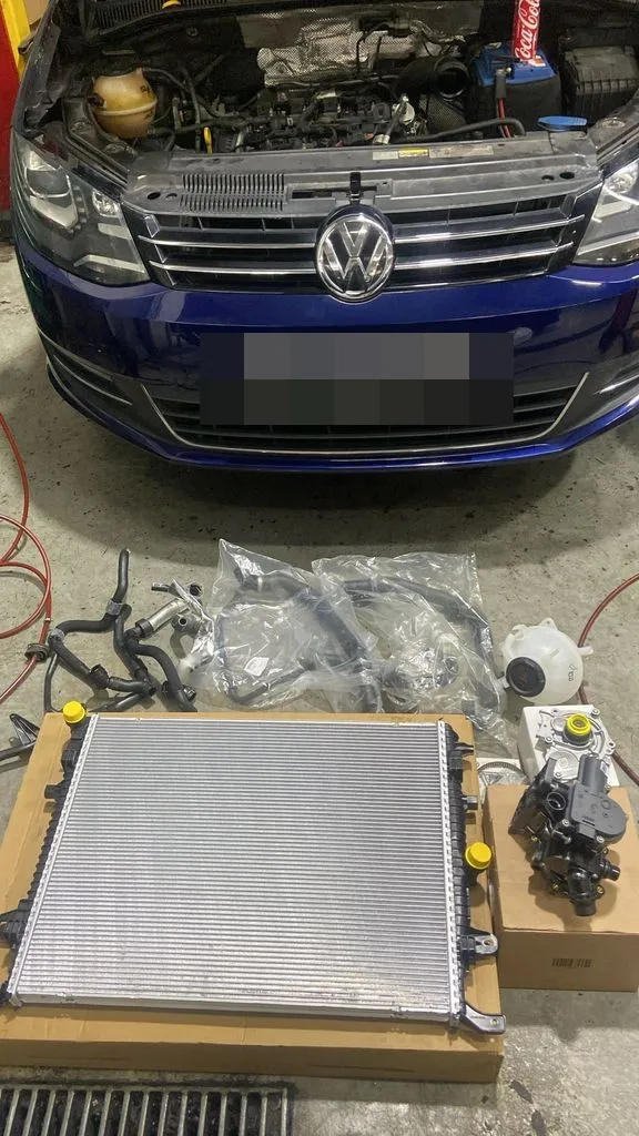 Blue Volkswagen Sharan at our Singapore workshop with a new radiator and coolant hoses laid out for a cooling system repair