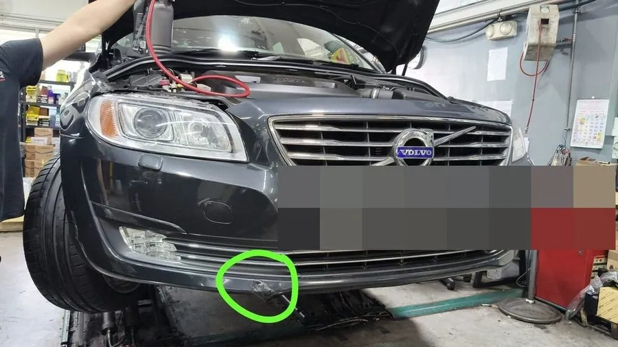 Volvo S80 in our workshop with the bonnet open, its existing front bumper damage circled