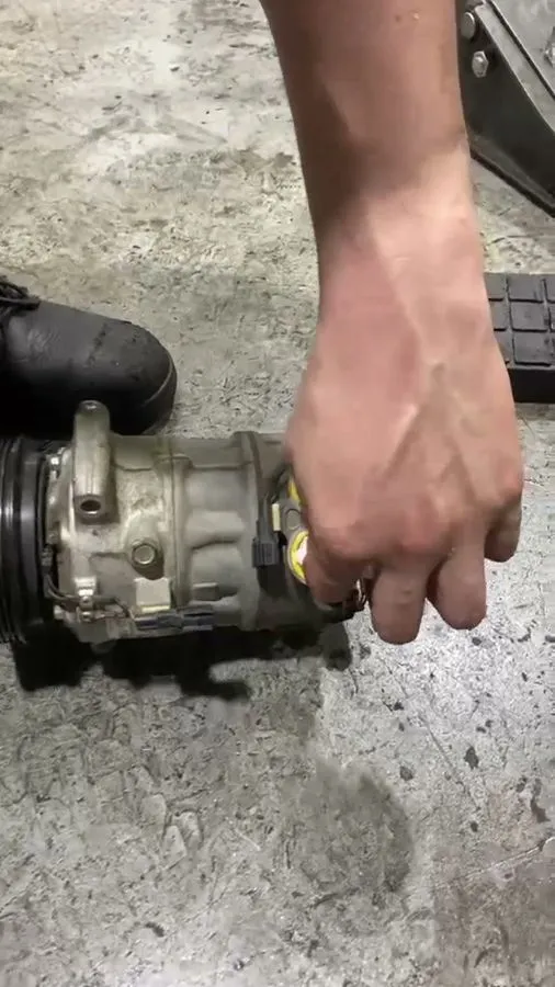 Faulty Volvo S80 AC compressor removed from the car, showing wear on the unit