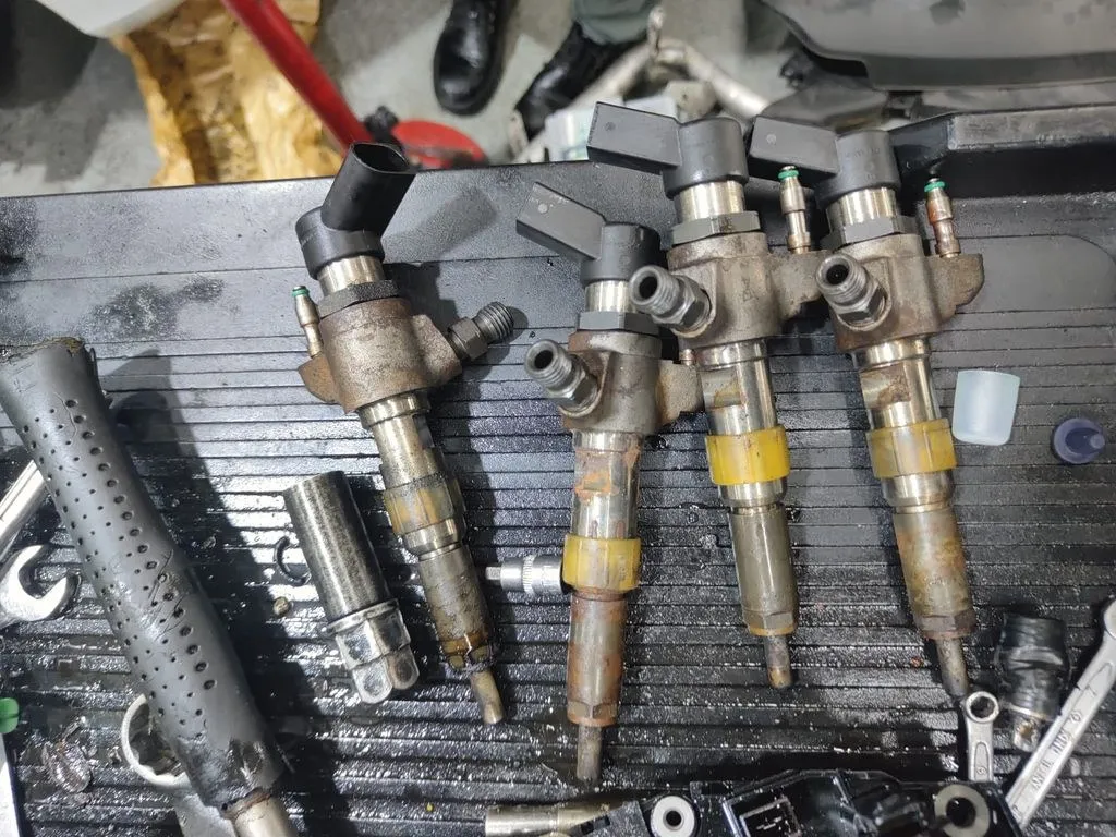 Four worn fuel injectors removed from a Volvo V40 during diagnosis at our Singapore workshop
