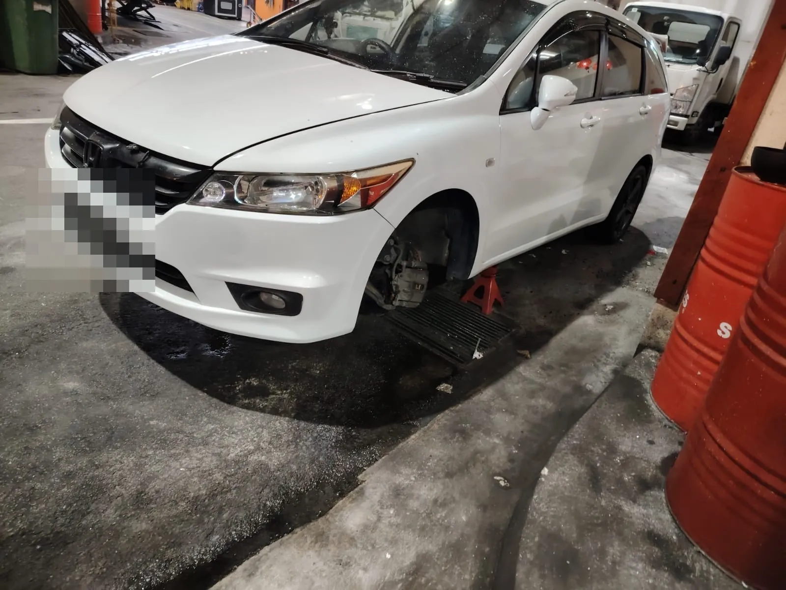 Customer's car with the front wheel removed for hub work at our Singapore workshop