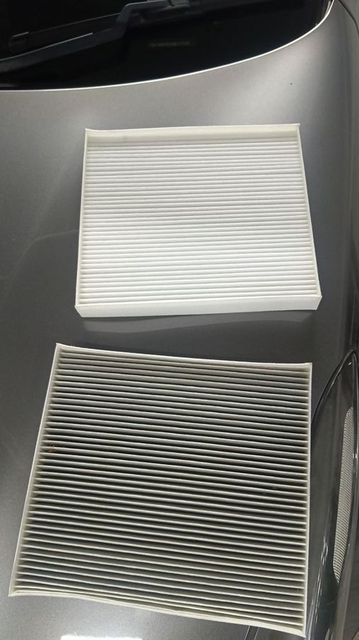 Old and new cabin air filters side by side from the Kia Sportage, showing how dirty the old filter was